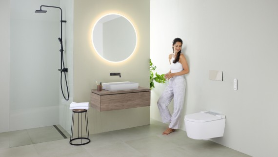 Woman in front of bathroom mirror (© Geberit)