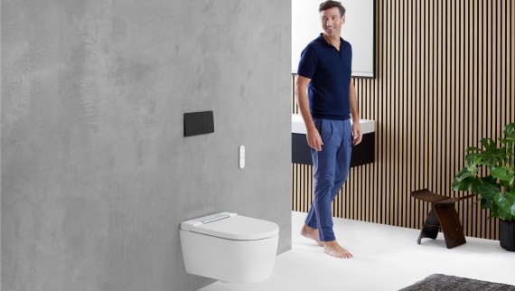 Man in the bathroom looking at the WC area featuring a Geberit toilet