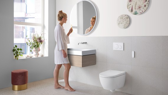 Woman in white bathroom with ceramic appliances and bathroom furniture