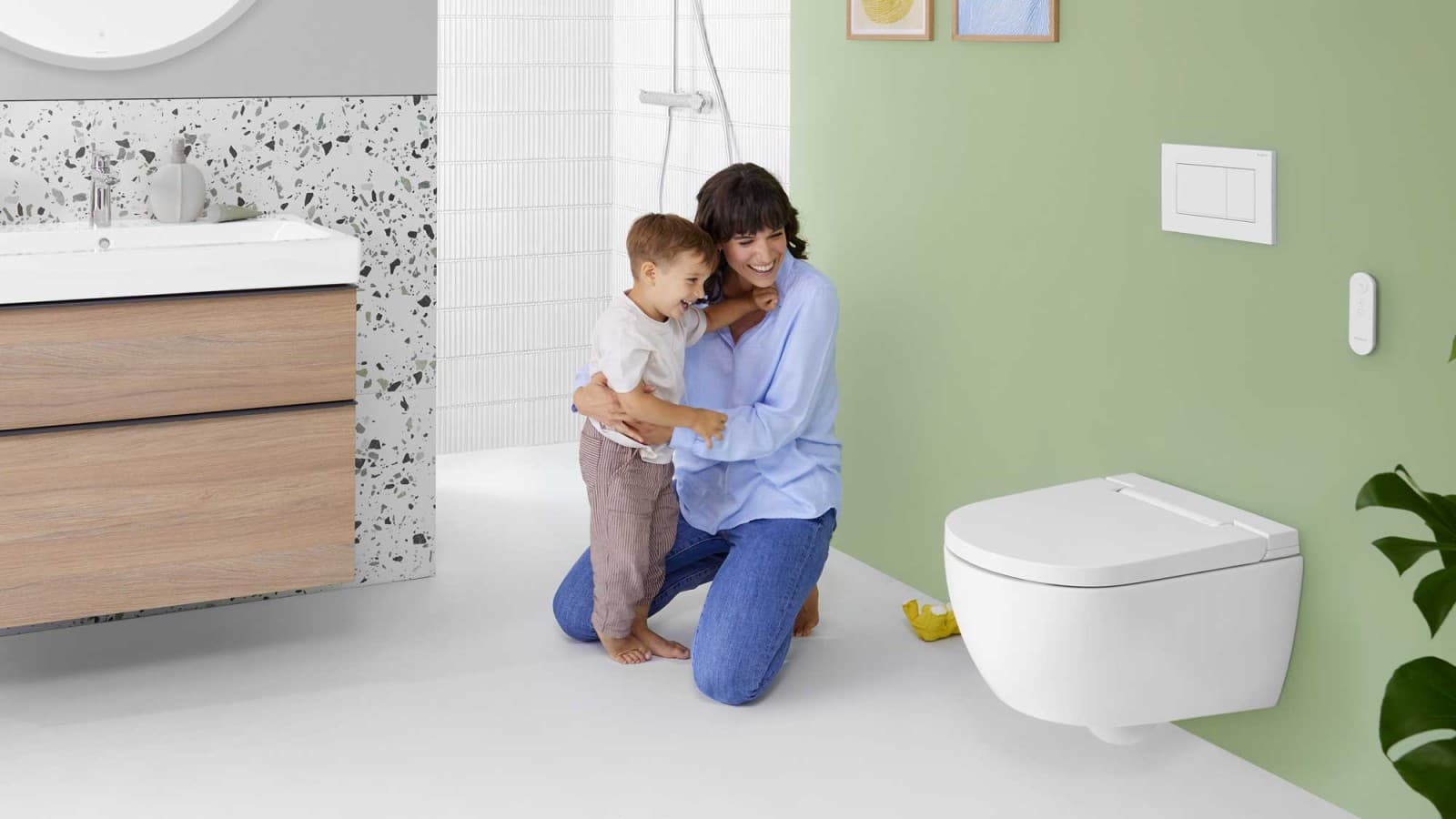 Woman with child in front of a Geberit AquaClean Alba shower toilet Woman with child in front of a Geberit AquaClean Alba shower toilet